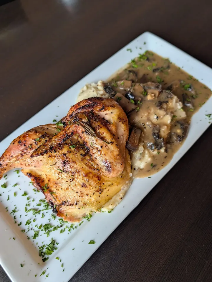 Rosemary roasted half chicken over mashed potatoes with mushroom gravy